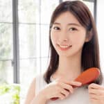 ブラシとほほ笑む女性